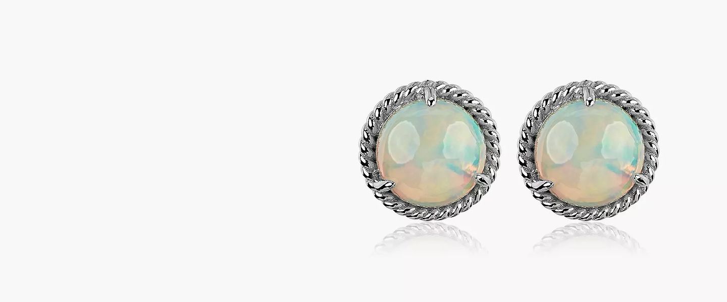 White opals in cabochon cuts featured in a pair of stud earrings